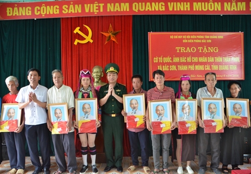 Bac Son border post presents national flags and Uncle Ho’s photos to local people