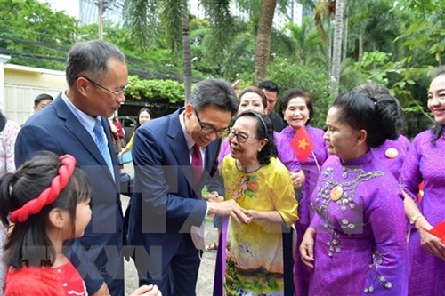Le vice-Premier ministre Vu Duc Dam rencontre des Vietnamiens en Thaïlande