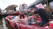 Bun rieu servido en un bote rosado en un mercado flotante